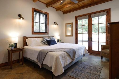 1 dormitorio con 1 cama grande y 2 ventanas en Little Dutch Cabin #1 - 12 min to Magnolia-Baylor, en Bellmead
