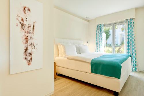 a white bedroom with a bed and a window at 7Pines Resort Ibiza, part of Destination by Hyatt in San Jose