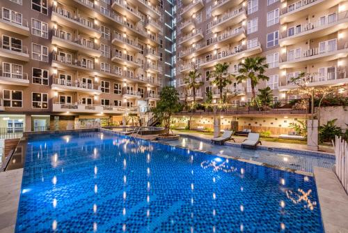 a large swimming pool in front of a building at Grande Valore Hotel Cikarang in Cikarang