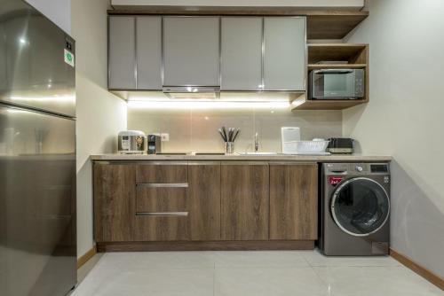 a kitchen with a washing machine and a washer at Grande Valore Hotel Cikarang in Cikarang
