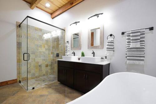 a bathroom with a shower and a sink and a tub at Little Dutch Cabin #3 - 12 min to Magnolia-Baylor in Bellmead