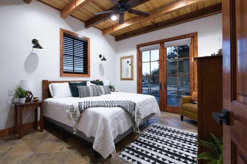 Little Dutch Cabin #3 - 12 min to Magnolia-Baylor في Bellmead: غرفة نوم بسرير ومروحة سقف