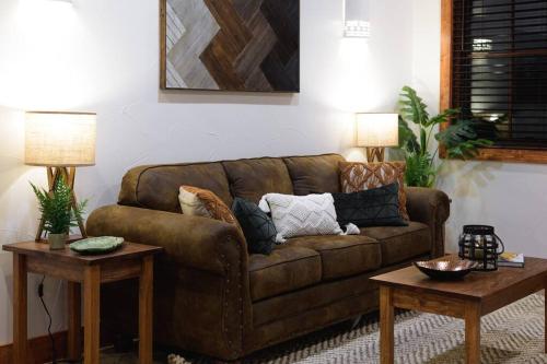 a living room with a brown couch and two tables at Little Dutch Cabin #3 - 12 min to Magnolia-Baylor in Bellmead