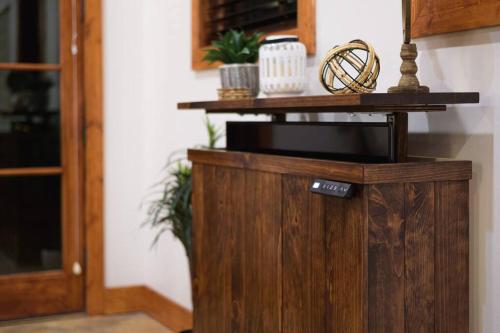 a wooden cabinet in a living room next to a door at Little Dutch Cabin #3 - 12 min to Magnolia-Baylor in Bellmead
