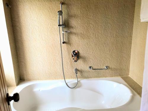 a bath tub in a bathroom with a shower at Himalayan Deurali Resort in Pokhara