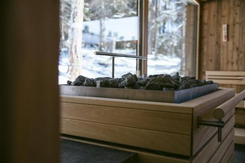 a bathroom with a tub filled with rocks next to a window at Josef Mountain Resort in Avelengo
