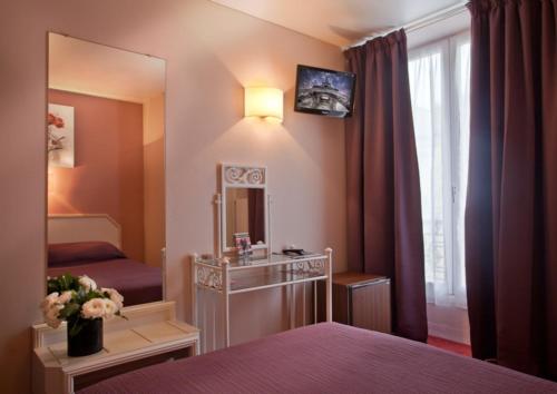 a hotel room with a bed and a mirror at Hôtel de l'Alma Paris in Paris