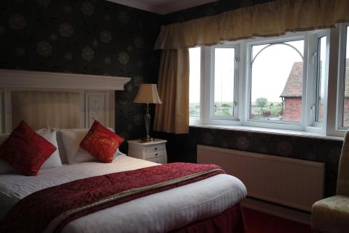 a bedroom with a bed and two windows and a bed sidx sidx sidx at Gable End Hotel in Great Yarmouth