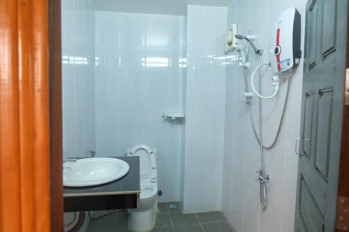 La salle de bains blanche est pourvue d'une douche et d'un lavabo. dans l'établissement Mondulkiri Holiday homestay, à Saen Monourom