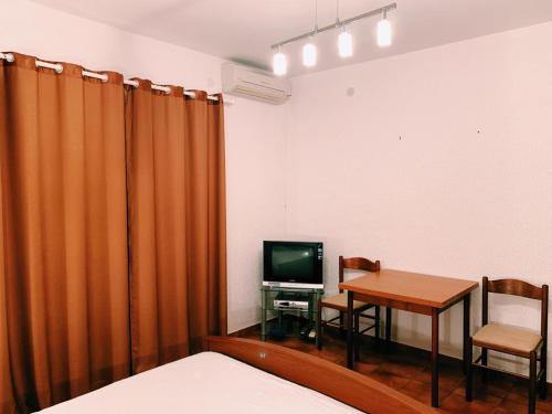 巴尔Бар Шушань Апартаменты Главановича 25的一间设有桌子、电视和床的房间
