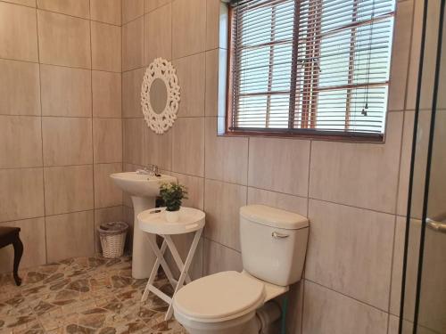 a bathroom with a toilet and a sink at GUINEA FOWL in Plettenberg Bay