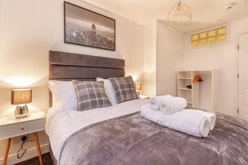 um quarto com uma cama grande e toalhas em Guest Homes - New Street Suite em Worcester