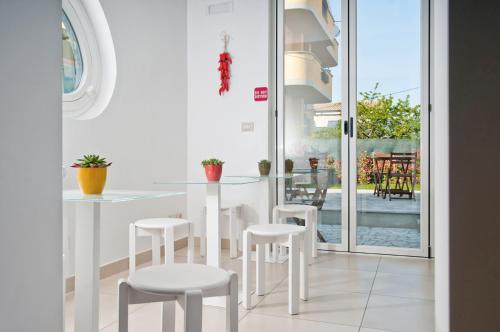 a white kitchen with a table and white stools at Bedrooms B&B in Pescara