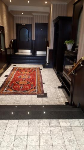 a hallway with a rug on the floor and a piano at Gasthof Sommer in Bösel