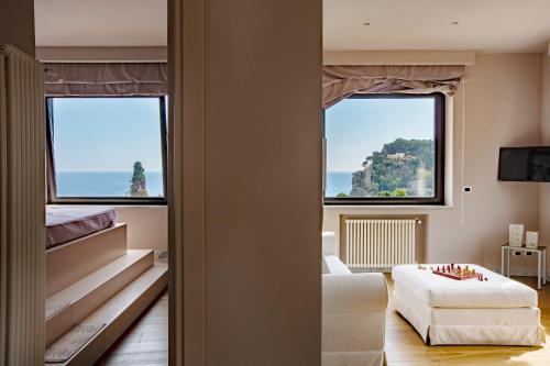 a living room with two large windows and a couch at Fenetre sur le blue in Taormina