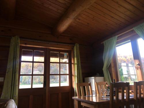 a dining room with a table and a large window at Log home village in Ulverston