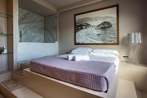 a bedroom with a bed with a picture on the wall at Fenetre sur le blue in Taormina