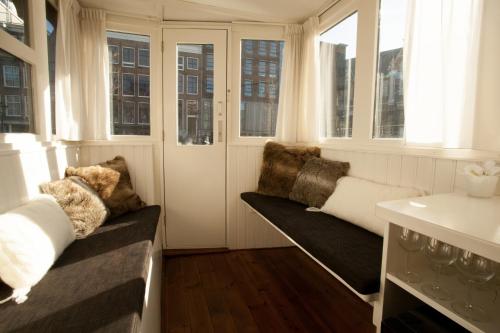 um quarto com janelas, um sofá e um lavatório em Prince Royal B&B em Amsterdã