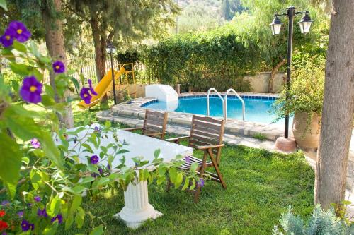 a swimming pool with a table and two chairs next to it at Villa Daskalogianni in Vlakhianá