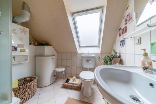 een badkamer met een bad, een toilet en een raam bij Private Rooms in Hannover