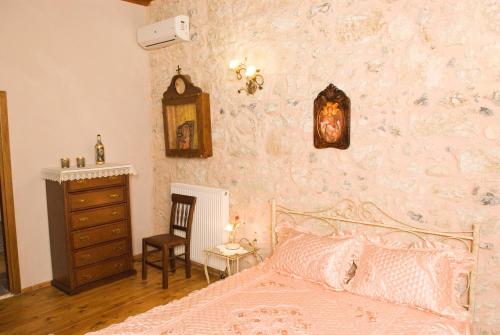 a bedroom with a bed and a dresser and a wall at Villa Daskalogianni in Vlakhianá