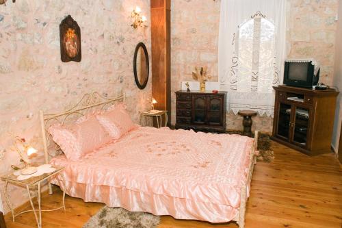 a bedroom with a bed and a tv in it at Villa Daskalogianni in Vlakhianá