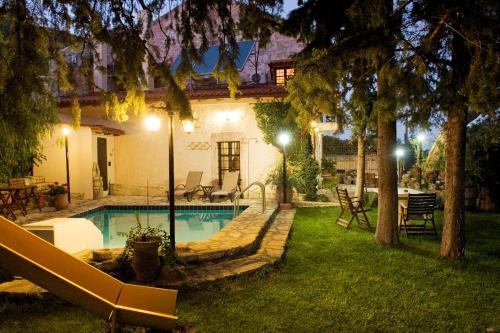 a swimming pool in the yard of a house at night at Villa Daskalogianni in Vlakhianá