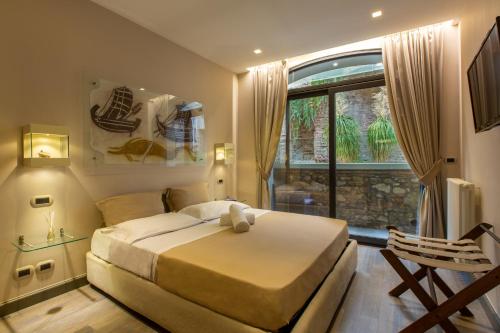 Un dormitorio con una cama grande y una ventana en Le Jardin Romain, en Taormina