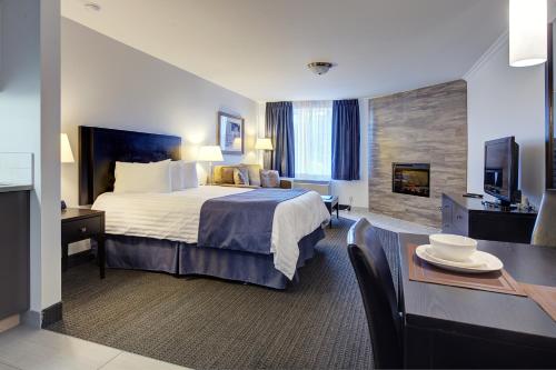 a hotel room with a large bed and a table at Hotel Vacances Tremblant in Mont-Tremblant