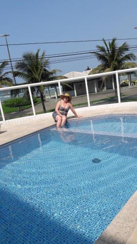a woman sitting next to a swimming pool at Mar Azul in Solemar