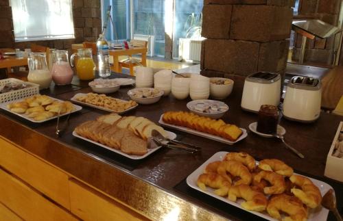 ビージャ・ラ・アンゴストゥーラにあるHosteria ACA al Surのペストリーなどの朝食用食品を盛り付けたテーブル