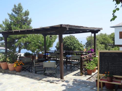 a wooden pergola with tables and chairs on a patio at Villa Enallaxis in Agios Dimitrios