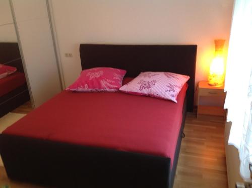 un letto con due cuscini rosa sopra di FeWo König a Milbitz