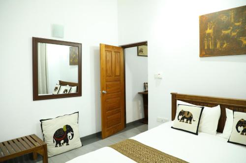 a bedroom with a bed and a mirror at Kandy Wellington Apartment in Kandy