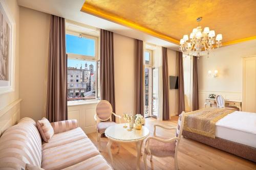 ein Hotelzimmer mit einem Bett und einem Wohnzimmer in der Unterkunft Piazza Heritage Hotel in Split