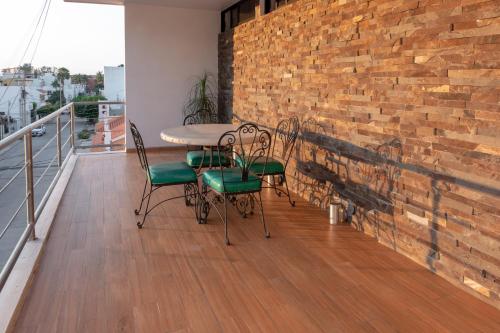 balcón con mesa, sillas y pared de ladrillo en Apartamentos Torre II Condominios - Pet Friendly, en Mazatlán