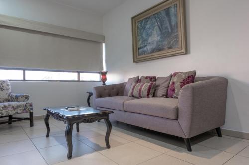 a living room with a couch and a table at Apartamentos Torre II Condominios - Pet Friendly in Mazatlán