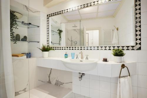 a white bathroom with a sink and a mirror at Casa Cosi - Maria Novella in Florence