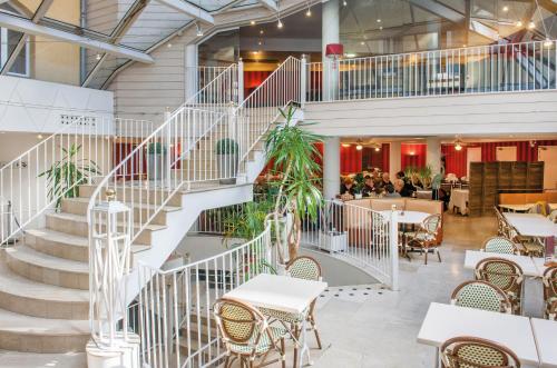 a staircase in a restaurant with tables and chairs at Hôtel Saint Sauveur in Lourdes
