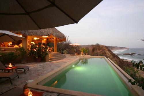 a swimming pool with a view of the ocean at Hotel Casa Pan de Miel (Only Adults) in Mazunte
