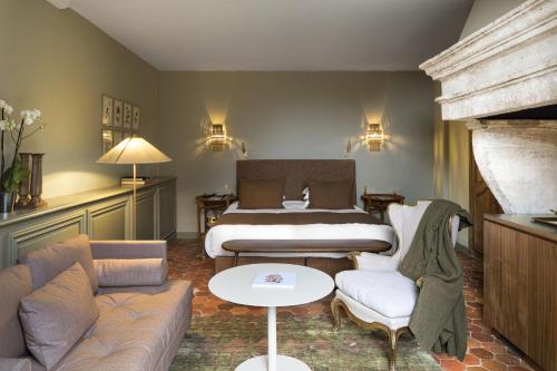 a bedroom with a bed and a couch and a table at Baumanière - Les Baux de Provence in Les Baux-de-Provence