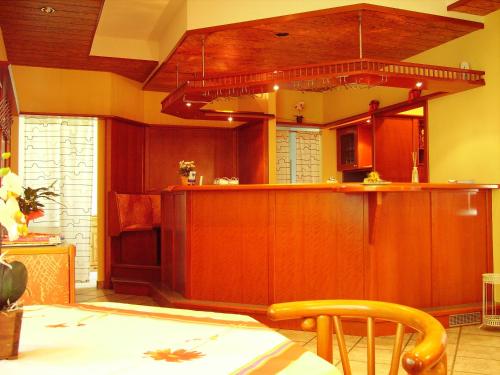 a kitchen with wooden cabinets and a wooden table at Hotel Siegmar im Geschäftshaus in Chemnitz