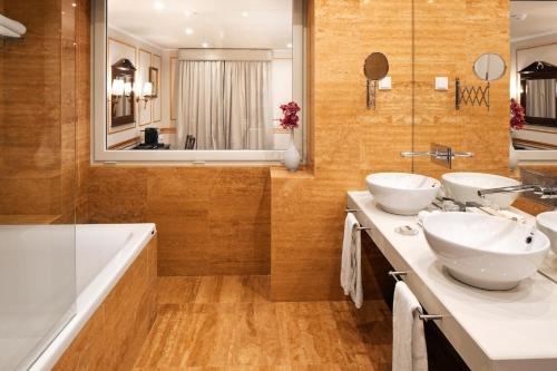 a bathroom with two sinks and a tub at Senhora da Guia Cascais Boutique Hotel in Cascais