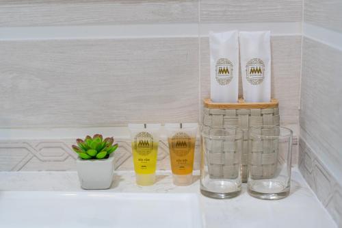 胡志明市的住宿－ViVo 416 Apartment，一个带玻璃和瓶子的浴室台面,以及植物