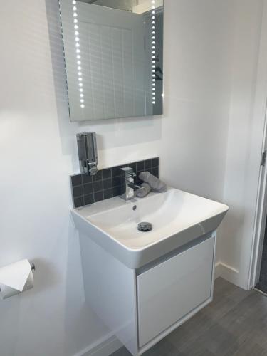 Baño blanco con lavabo y espejo en Rosemary House Accommodation-Nr Chew Valley en Bristol