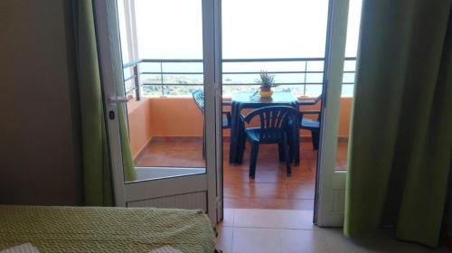 Cette chambre dispose d'une table, d'une chaise et d'un balcon. dans l'établissement Apartamento Villa, à Ponta do Sol