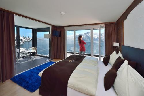 a woman standing in a hotel room with a bed at Seehotel Pilatus in Hergiswil