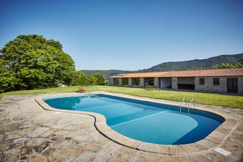 a swimming pool in a yard next to a house at Paço de Calheiros - Turismo de Habitação in Ponte de Lima