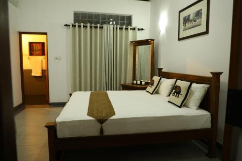 1 dormitorio con 1 cama grande y espejo en Kandy Wellington Apartment en Kandy