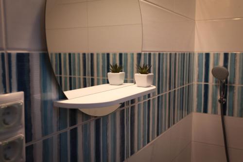 a bathroom with a sink and potted plants on a wall at Airport Almáskert Panzió in Vecsés
